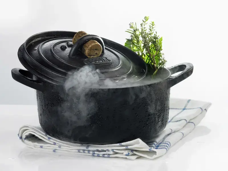 A steaming, black Dutch oven.