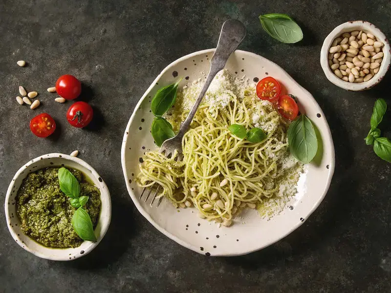 Classic italian spaghetti pasta with pesto sauce, pine nuts, olive oil and fresh basil