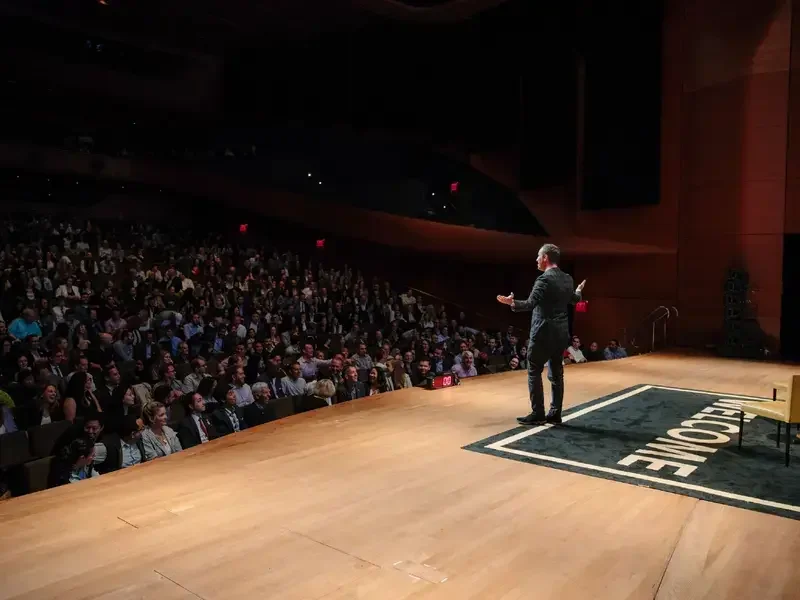 Will Guidara on stage presenting to a packed theatre