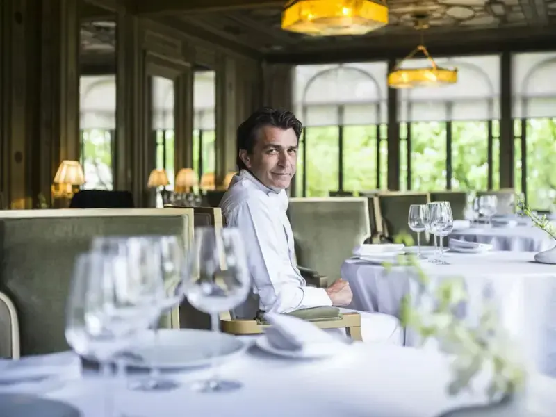 Yannick Alléno seated in an empty restaurant.
