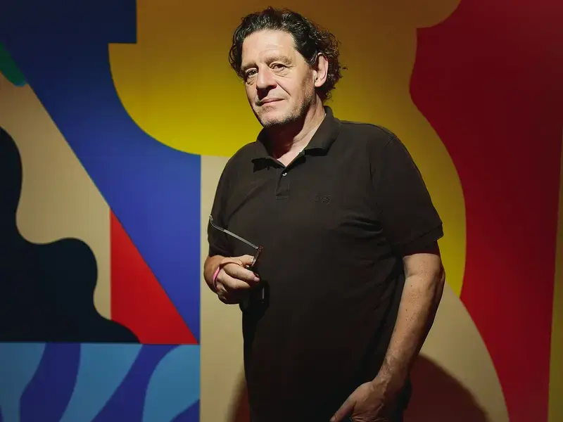 Chef Marco Pierre White in front of a colourful background.