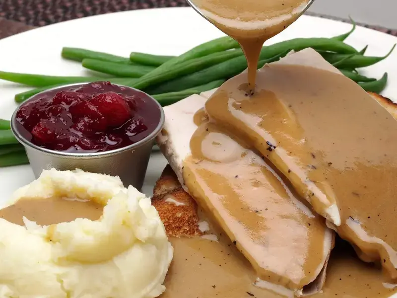 pouring gravy on plate ©iStock