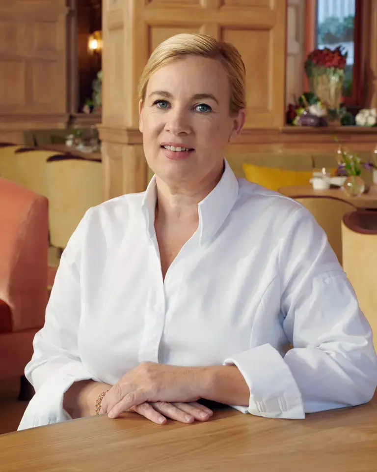 Chef Hélène Darroze sitting in a restaurant dining room.