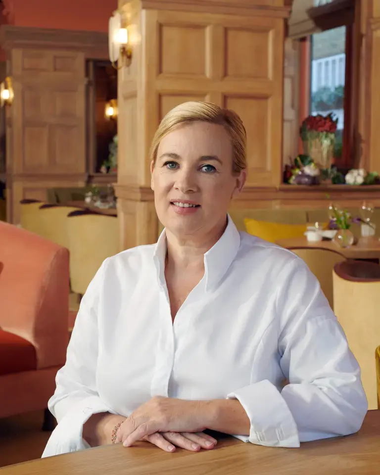 Chef Hélène Darroze sitting in a restaurant dining room.