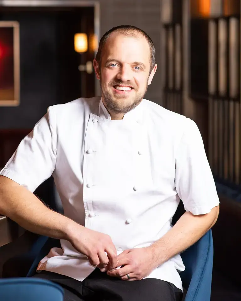 Chef James Knappett sitting on a chair.