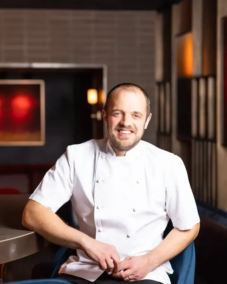 Chef James Knappett sitting on a chair.