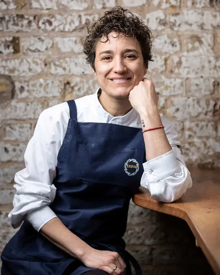 Chef Nieves Barragán Mohacho in front of a raw brick wall.