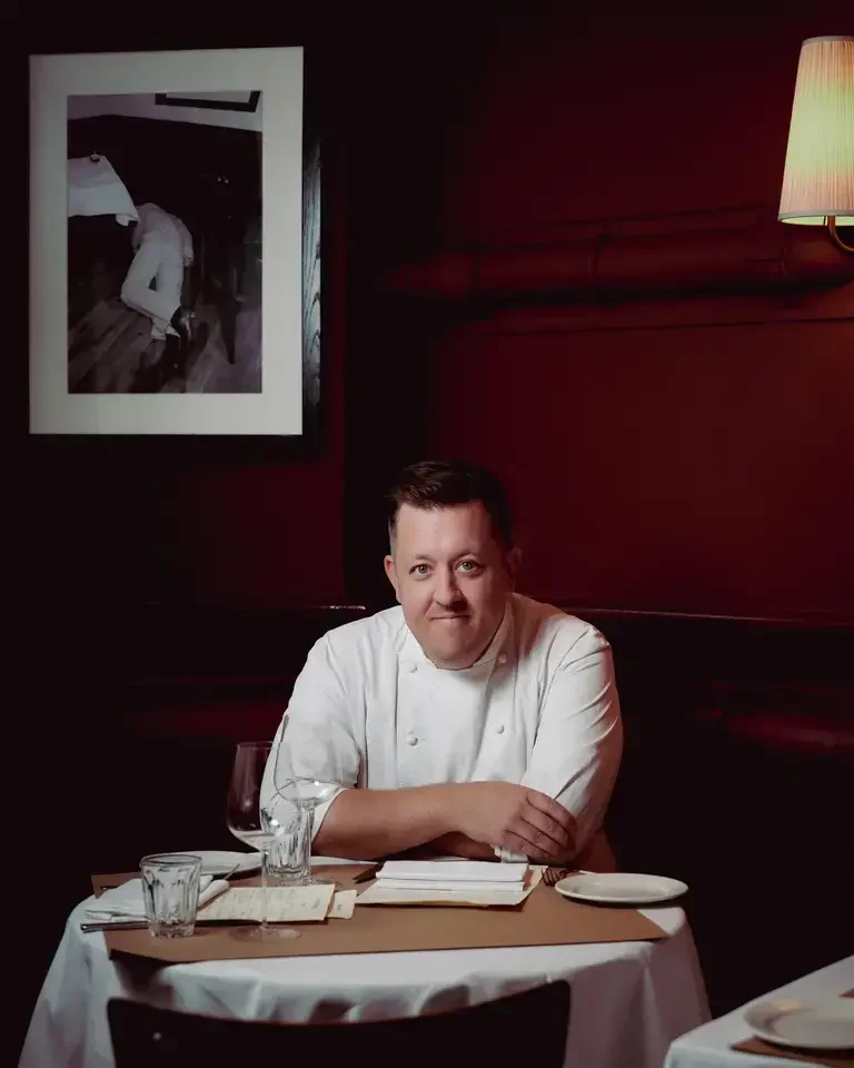 Chef Ashley Palmer-Watts at a restaurant table.