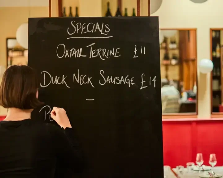 A woman writing on the blackboard at Camille.