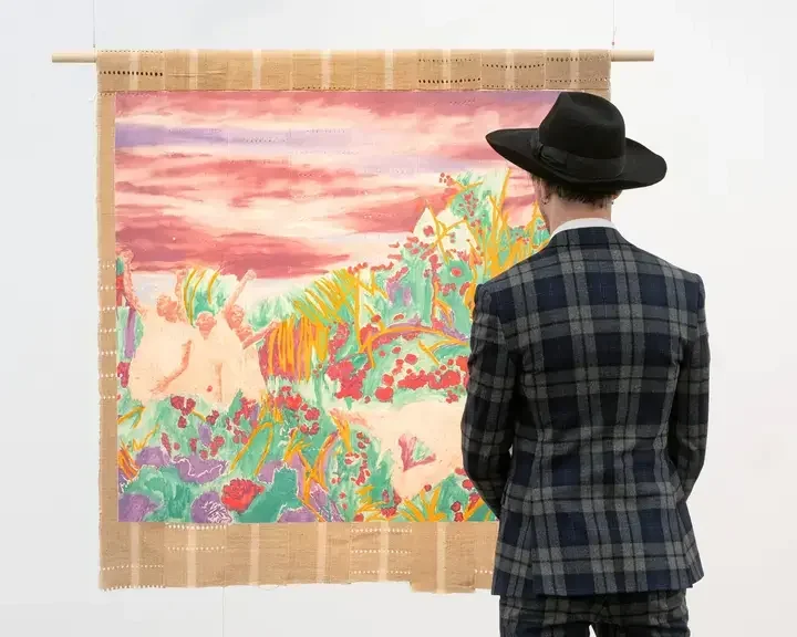 A man in a hat looking at an artwork at Frieze London 2024.