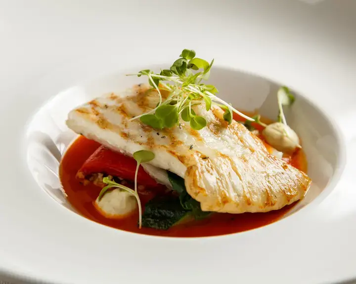Grilled fillet of turbot with vegetables and sauce.