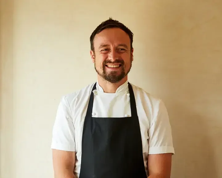 Chef Sam Carter smiling in an apron.