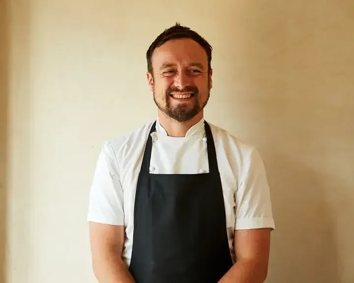 Chef Sam Carter smiling in an apron