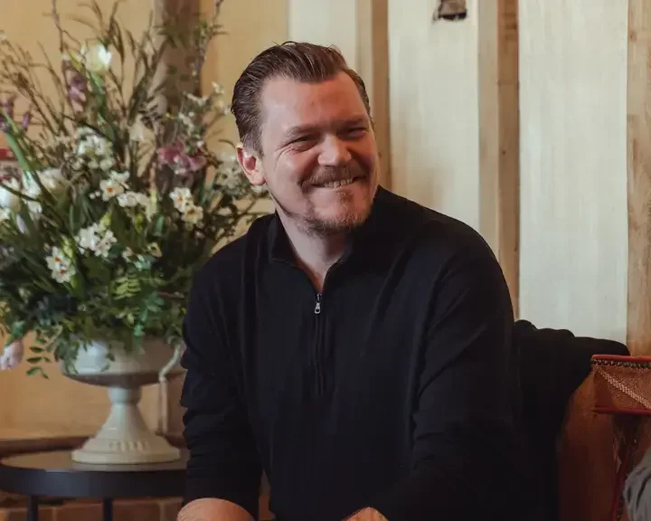 Chef Alex Dilling, seated and smiling in casual clothes.