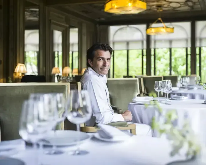 Yannick Alléno seated in an empty restaurant.